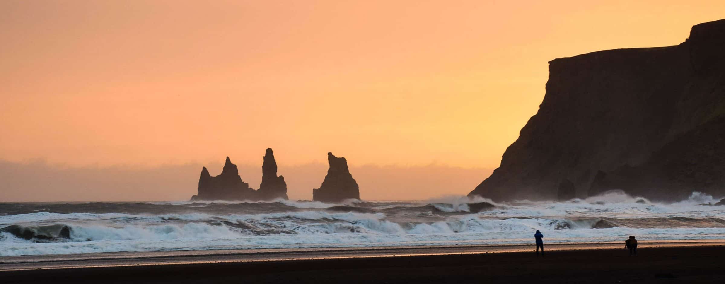 Sunset on a black beach in Iceland with cliffs