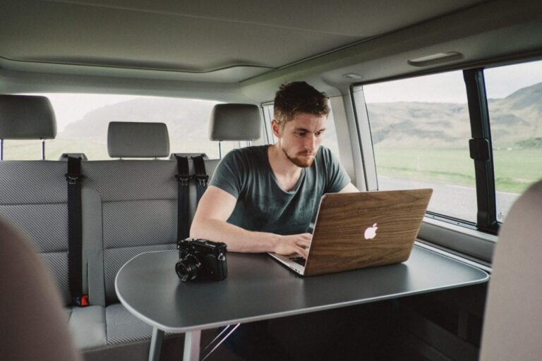 Man on laptop inside a VW California camper